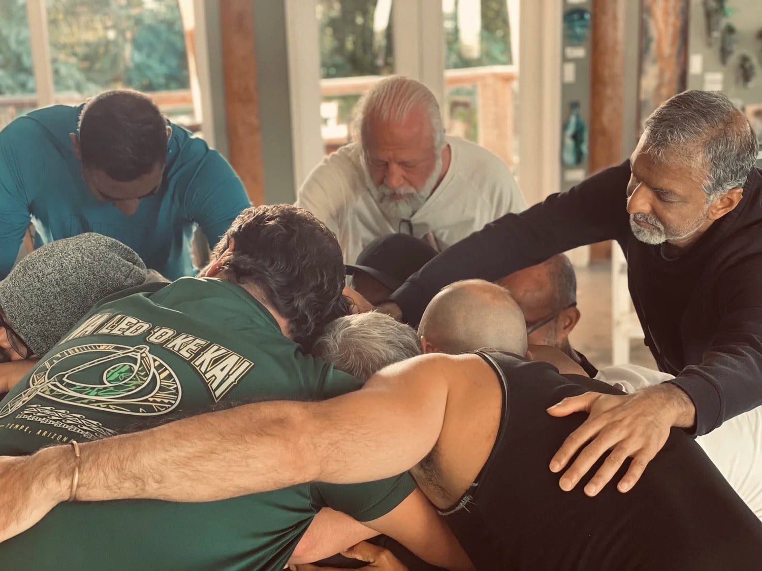 Men supporting one another in guided somatic practice