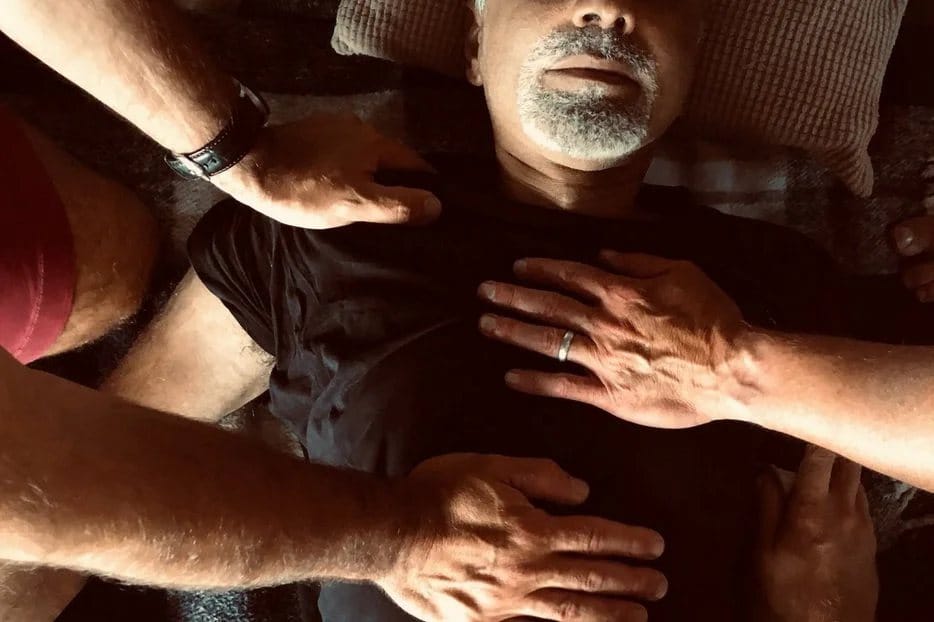 Hands resting on a chest — touch that listens